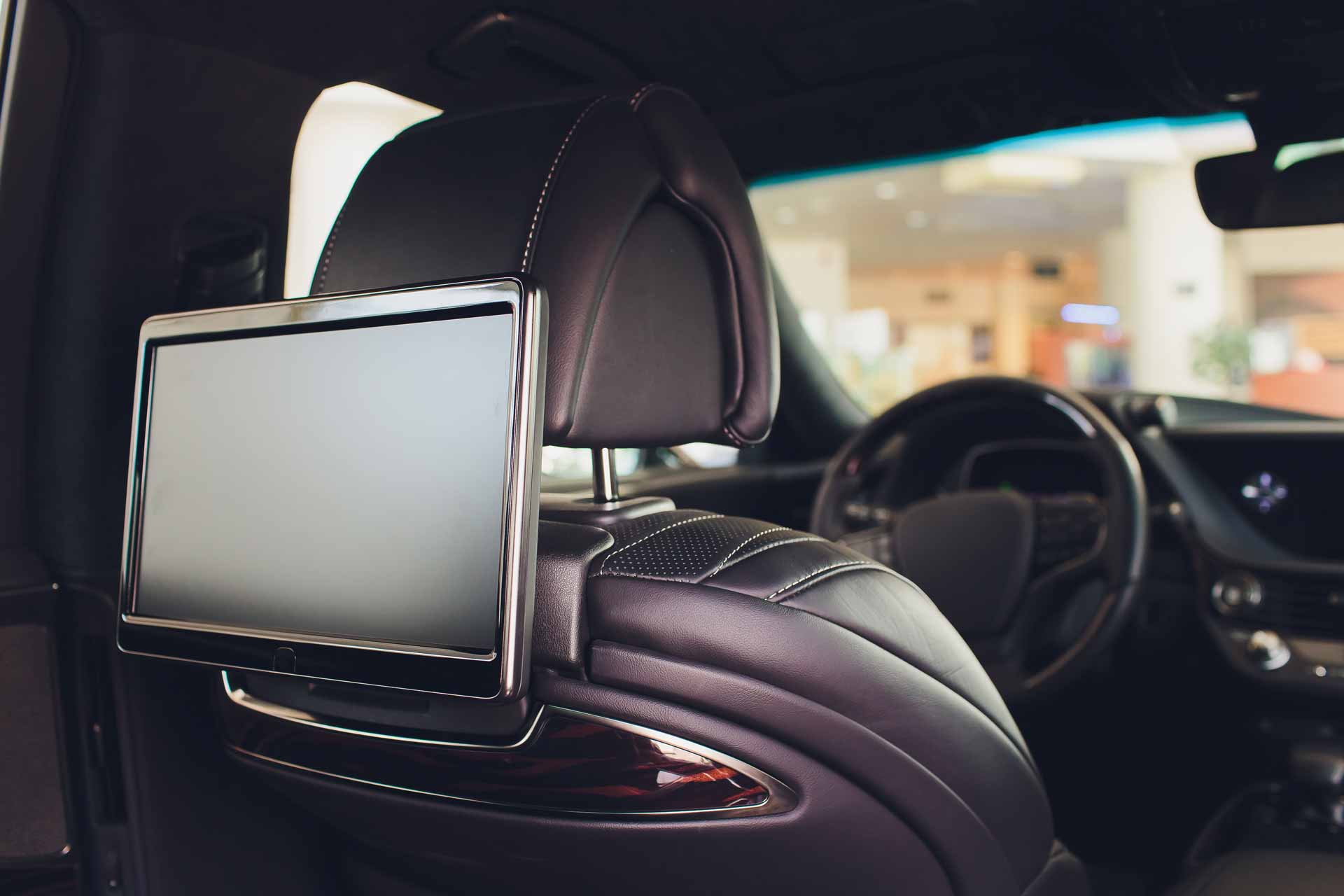 Video screen installed in car behind driver's headrest